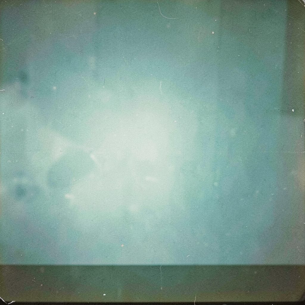 Atmospheric analog film photograph of an old desk telephone beside a yellow notepad, warm amber and teal tones, soft daylight, visible grain